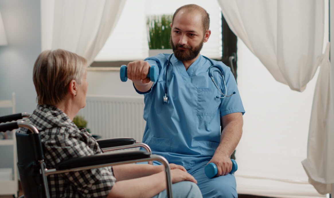 Medical assistant giving assistance to disabled old woman