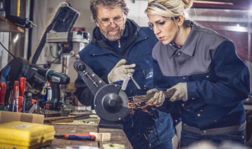 Young Woman Grinding Metal in Mechanical Workshop