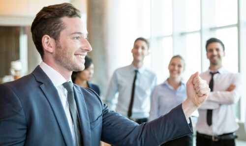 Cheerful leader motivating his business team