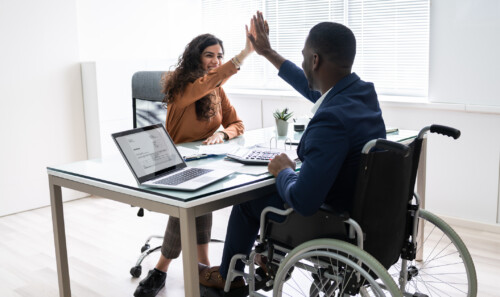 Disabled Businessman Giving High Five To His Partner
