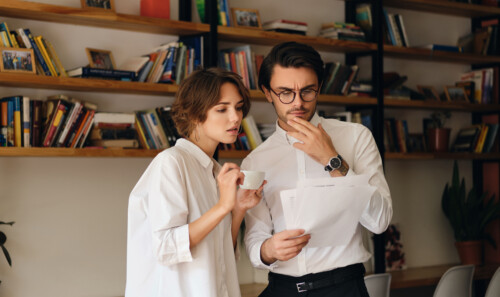 Young pensive business colleagues standing with papers thoughtfu